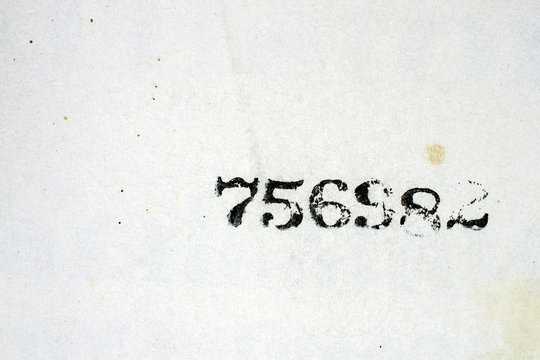 Black Numbers Stamped on a Stained Vintage Book Page