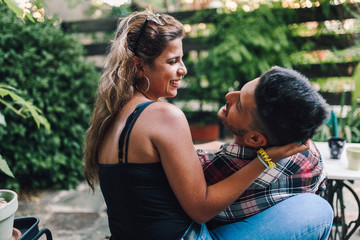 Young couple smiling sitting on the steps outside the wooden cabin