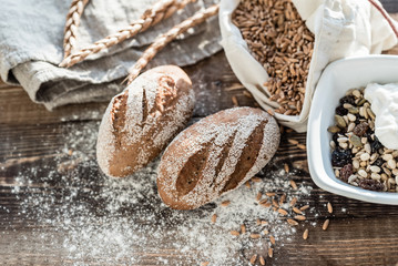 fresh bread with flour on the wooden background