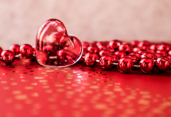 Shining transparent heart and a group of red beads. Perfect Valentine's Day greeting card background.