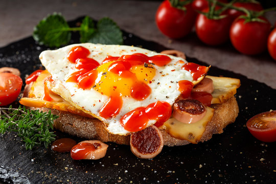 Open sandwich made with egg, cheese and sausages