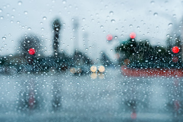 Waiting at a traffic junction for the green light during a rainy day; raindrops on the windshield