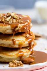 Close up pancakes with caramel and walnuts white background. Romantic breakfast