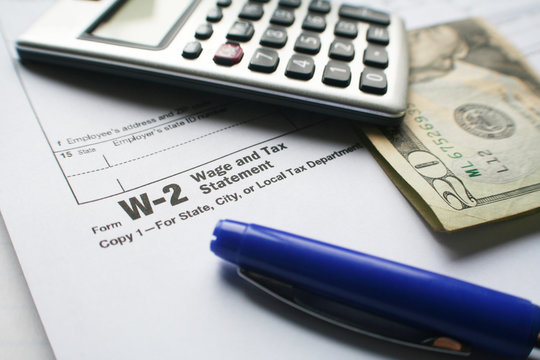 W-2 Tax Form With Calculator, Pen & Twenty Dollar Bill High Quality Stock Photo 