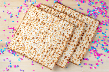 Pesach celebration concept. Matzah and confetti happy colorful background for Jewish Passover holiday.
