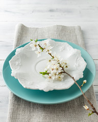 Spring table set with plates and white flowers