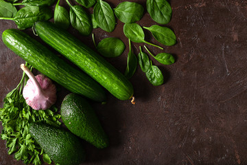 Creative background of green vegetables, cucumbers, avocado.