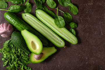 Creative background of green vegetables, cucumbers, avocado.