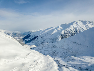 Aerial view of snow covered mountains in Swiss alps. Beautiful panorama of wild and tranquil backcountry in alpine area.
