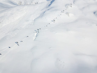 Fototapeta na wymiar Aerial view of ski chairlift on snow covered mountain in Switzerland