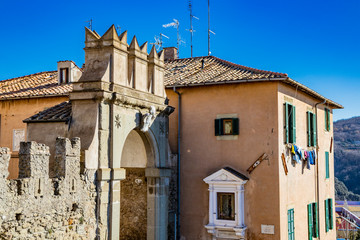 Fototapeta na wymiar Medieval door of Ariccia. Stone arch, coat of arms, entrance, niche. Castelli Romani, Lazio, Italy.