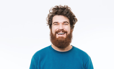 Portrait of happy bearded man in blue pullover smiling at camera