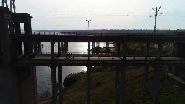 The span on the quadcopter parallel to the bridge on which the silhouettes of the running half-marathon athletes are shot