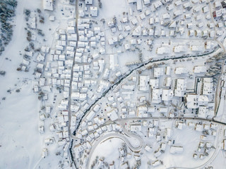 Aerial view of Andermatt town with snow covered roofs. Village in Switzerland in winter with a lot of snow.