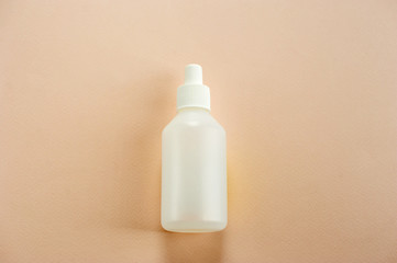 Plastic bottle with cap for medical liquids. Light background. Close-up. View from above.