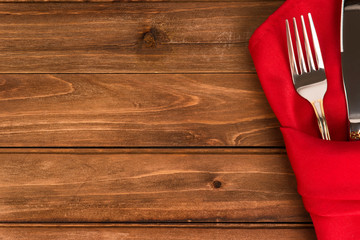 Close up on table settings with a red napkin and a cutlery, directly above. Copy space for your text.