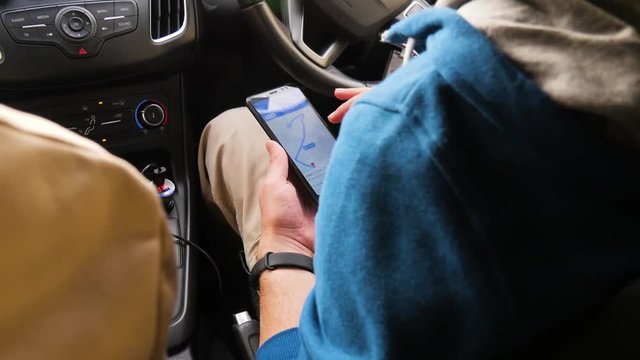 Tourists choose the direction on the map in the phone. The man is looking for a destination.