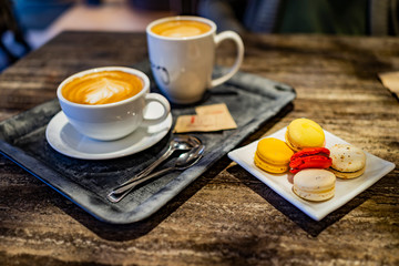 coffee and french macarons on wooden table