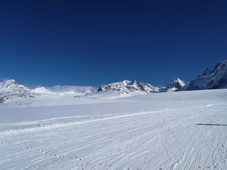 Beautiful panoramic view of snow-capped mountains with ski slopes in the Swiss Alps near Zermatt,...