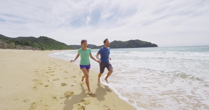 New Zealand Travel Vacation Holidays Couple Having Fun On Beach. Couple running on beach in love holding hands in New Zealand Abel Tasman National Park on Onetahuti beach, Tonga Bay. RED EPIC SLOW MO.