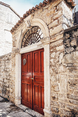 Ancient wooden door in old stone town with sandstone
