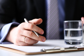 Arm fill and sign important form clipped to pad with silver pen