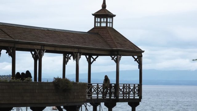 Tourists in the wooden pier of Fruttilar in the Llanquihue lake. 4k