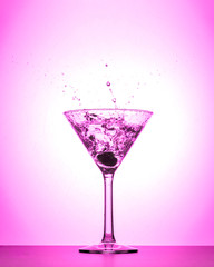 Cocktail martini glass splash on white and pink gradient background
