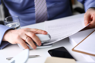 Male clerk arm pin together some papers with stapler