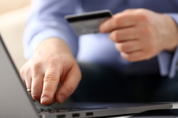 Male arms hold credit card press buttons making transfer