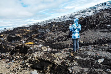 oung woman tourist photographing the landscape of hydrothermal activity between the glassier and mountain slope in Kverkfjoll massif