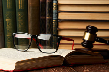Judge gavel and legal book collection with eyeglasses on wooden 