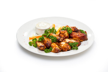 fried chicken wings with sauce and garnish of carrots and celery