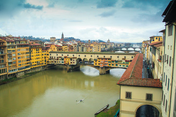 Ponte Vecchio bridge over Arno River with dark cloudy sky background in Florence,Tuscany, Italy	