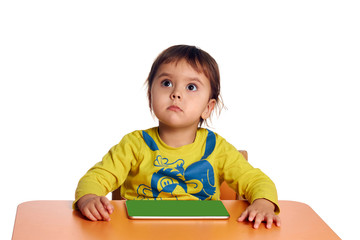 Adorable little child using digital tablet at desk, tablet pc with blank green screen, isolated on white background, shot in studio