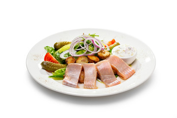 herring appetizer with onion potatoes and pickled cucumbers and garlic sauce
