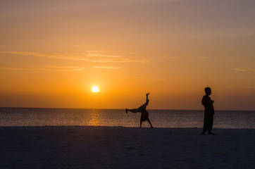 Fototapeta premium African kids playing on the sand in sunset beach