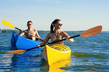 Couple kayaking together enjoying summer day on the lake