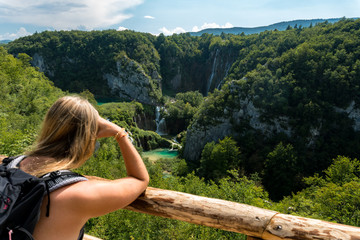 woman with backpack looking over a valley in plitvice national park