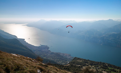 View on Garda lake and paragliders from the mountain Monte Baldo, Malcesine, Lombardy, Italy.