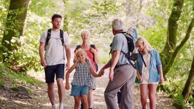 Slow Motion Shot Of Multi Generation Family Walking Towards Camera Along Woodland Path Together