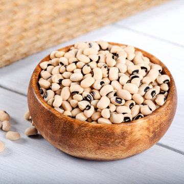 White kidney beans in bowl on wooden background.