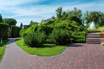 pavement walkway with drainage system for walking from the house to the fountain with a staircase and stone steps in the park.
