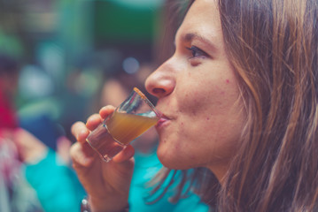 tourist girl drinking typical drink from south and central america called "chicha" in the city of Bogotà, Colombia