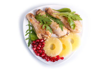 Fried chicken legs with rucola, pineapple and pomegranate seeds isolated on white background.