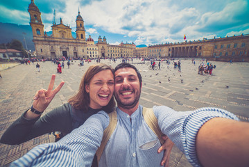 Happy young man taking a selfie photo in Bogota, Colombia. in the main square of the city called Bolivar square - obrazy, fototapety, plakaty