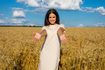Young woman on a background of golden wheat field