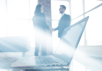 Obraz premium laptop on the desk, background handshake