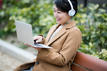 パソコンで音楽を聴く女性