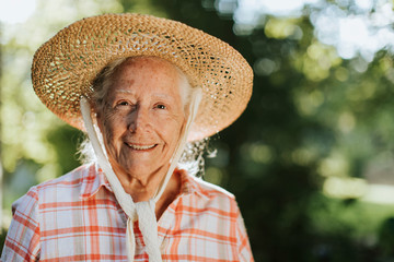 Fototapeta premium Portrait of a happy senior woman with a straw hat